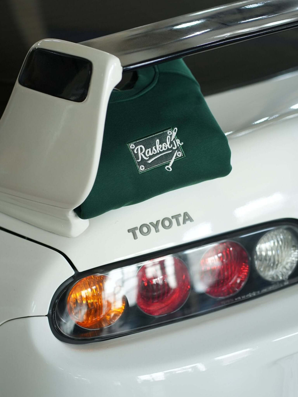 Raskol JR. Nefti Yeşil Sweatshirt displayed on a Toyota car, emphasizing denim detail and sporty lifestyle.
