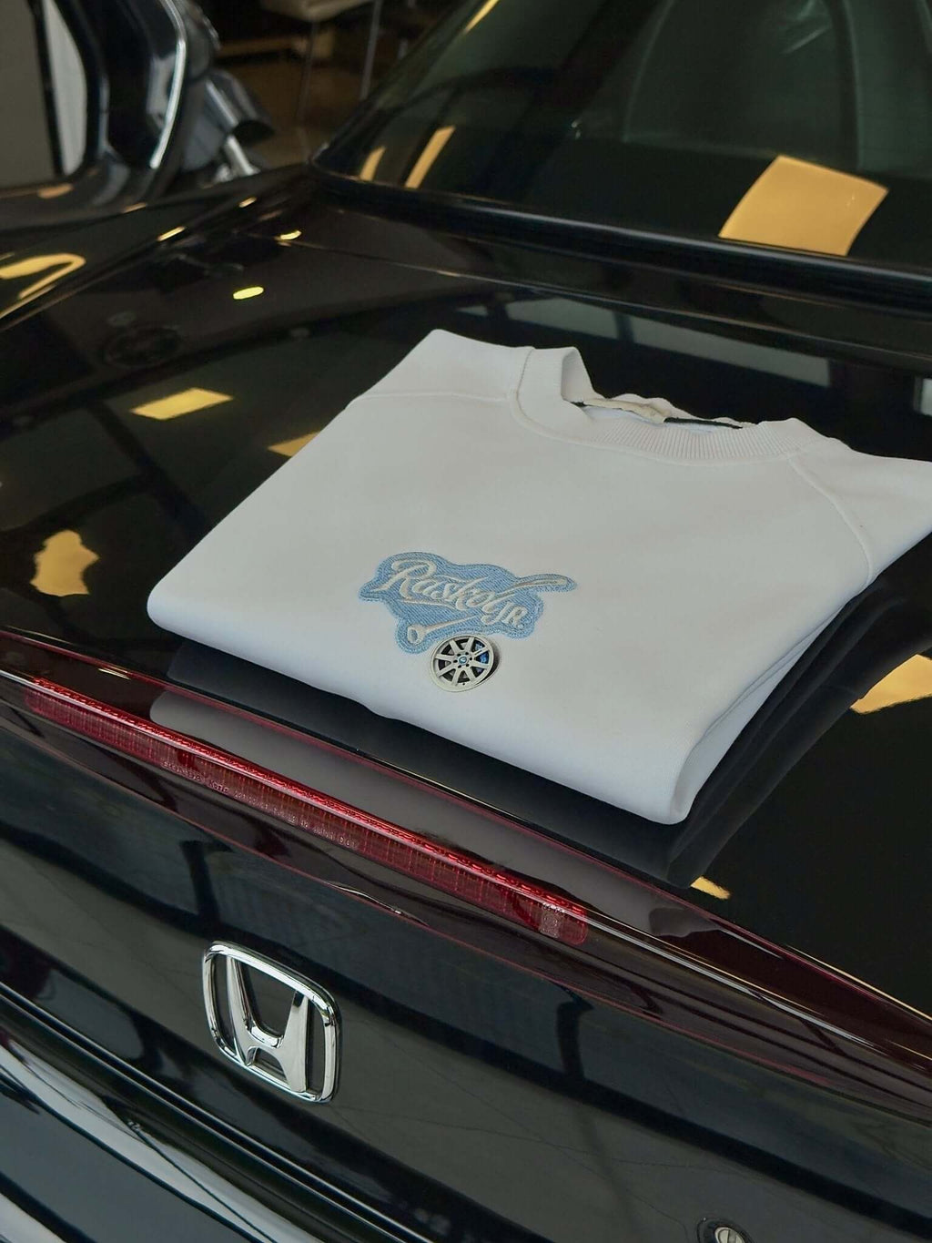 Raskol JR. Ekru Beyaz Mavi Denim&Jant Detaylı Sweatshirt folded on a Honda car trunk.